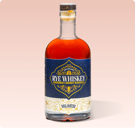 A bottle of Pollinator Rye Whiskey with a label that includes the brand name and the words 'finished with honey barrels' indicating a honey barrel finish.