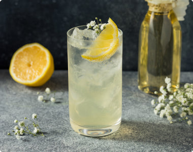 Elderflower Breeze cocktail served in a highball glass with lemon twist garnish