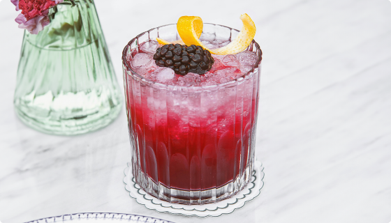 Bees & Berries cocktail made with Pollinator Gin, Crimson Amaro, honey, and fresh berries