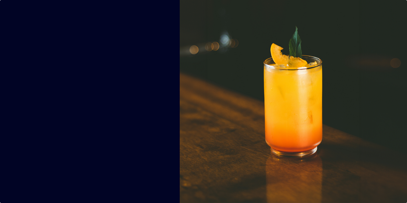 Peach & Rye Smash cocktail with mint garnish and fresh peach slices in a rocks glass
