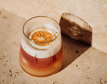 Golden Hour Sour cocktail made with Pollinator Crimson Amaro, served in a coupe glass with lemon garnish